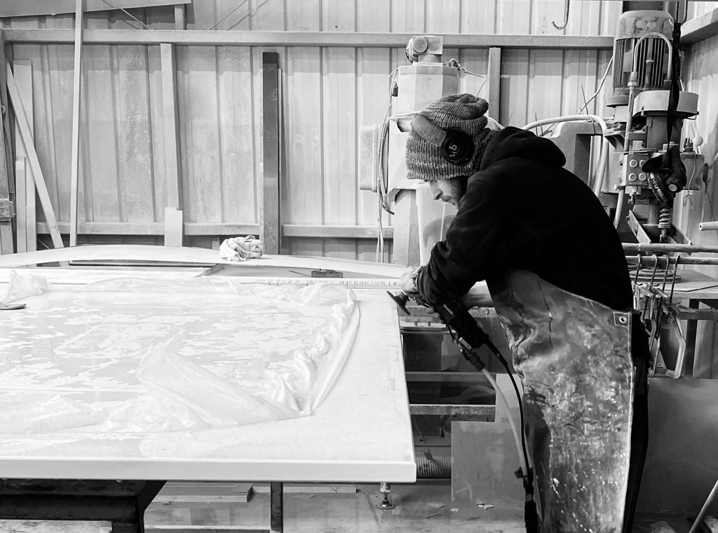 Craftsperson hand-finishing a stone worktop in the Amaris Bridgend workshop